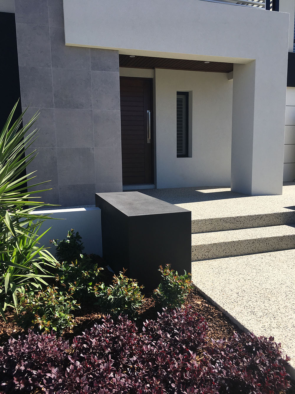 An elegant house in Perth with a landscaped front garden with exposed aggregate leading to the main door.