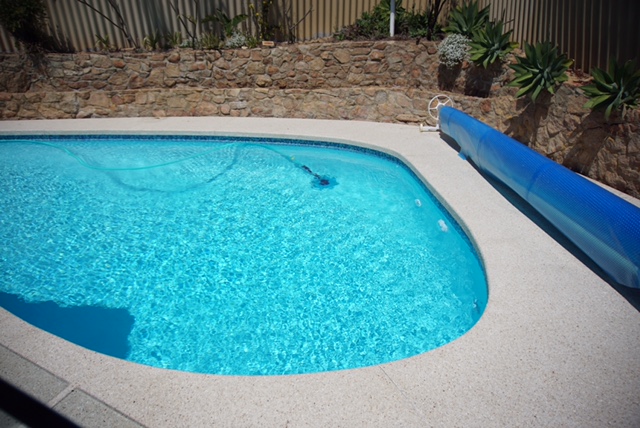 An alluring swimming pool in Perth with exposed aggregate on the side.